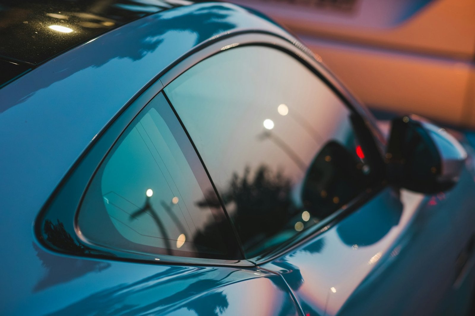 Close-up of a tinted rear side window on a blue sports car